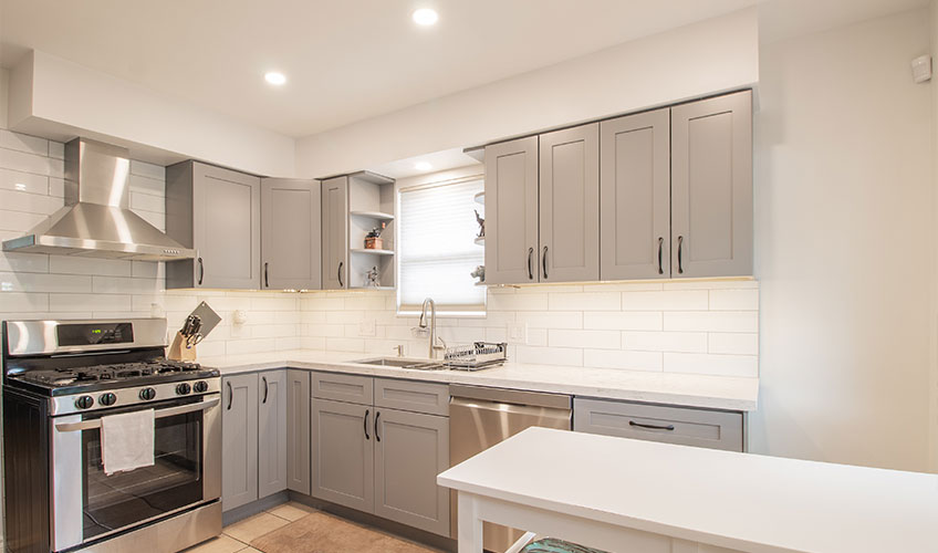 Kitchen with warm-toned white paint, creating a cozy atmosphere with gray accents and warm lighting