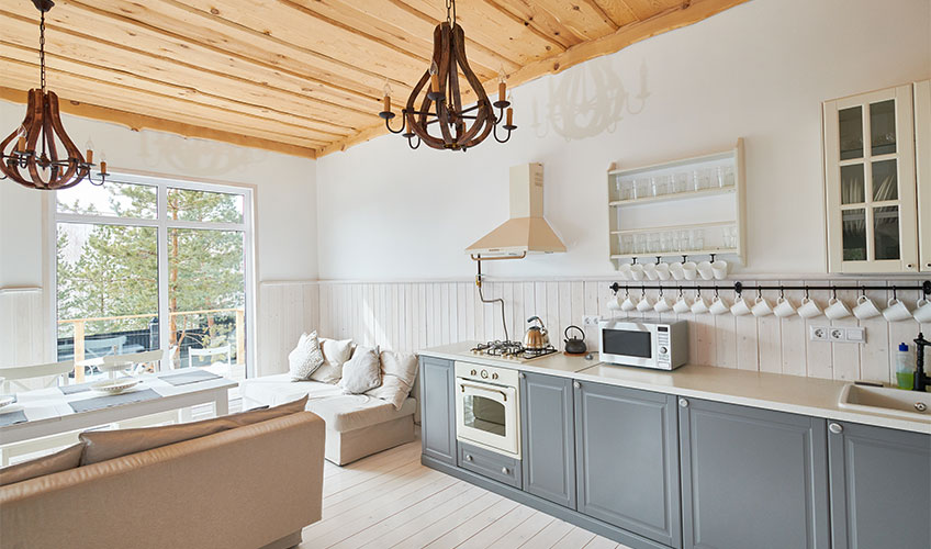 Bright white kitchen illuminated by natural light, featuring sleek cabinetry